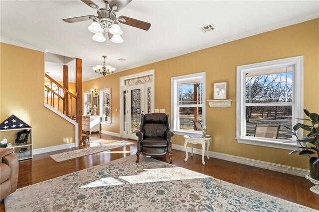 sitting room featuring ornamental molding, dark hardwood / wood-style floors, and ceiling fan with notable chandelier