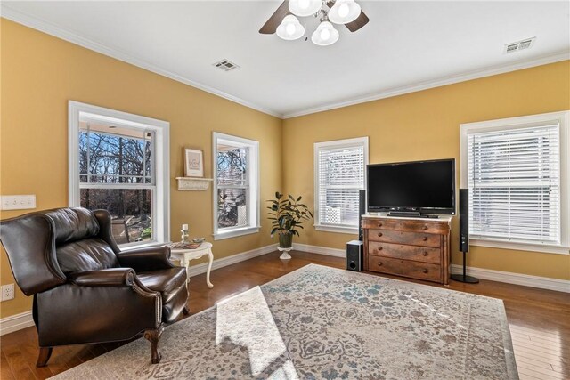 living room featuring crown molding, wood-type flooring, and a healthy amount of sunlight