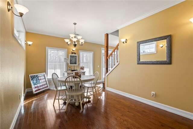 dining space with ornamental molding, dark wood-type flooring, and an inviting chandelier