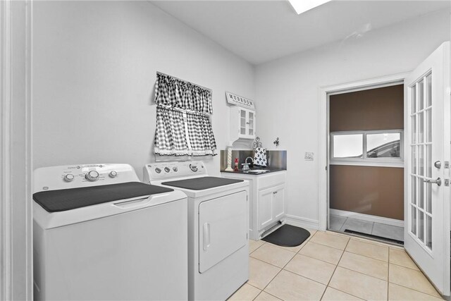 laundry area featuring separate washer and dryer, sink, cabinets, and light tile patterned flooring