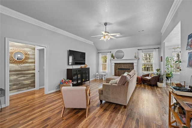 living room with lofted ceiling, wood-type flooring, ornamental molding, and ceiling fan