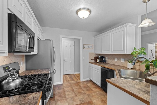 kitchen featuring white cabinets, sink, hanging light fixtures, and black appliances