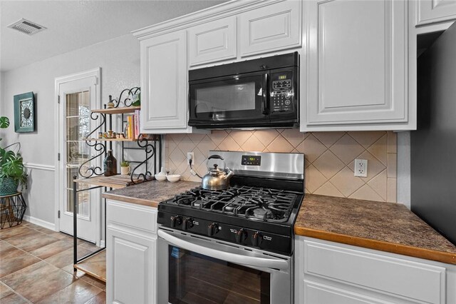 kitchen featuring white cabinetry, decorative backsplash, and gas stove