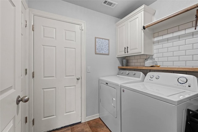 clothes washing area with washer and clothes dryer and cabinets