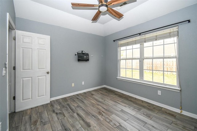 empty room featuring baseboards, lofted ceiling, wood finished floors, and ceiling fan