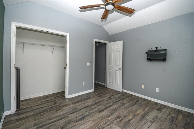 unfurnished bedroom with a closet, wood finished floors, lofted ceiling, baseboards, and ceiling fan