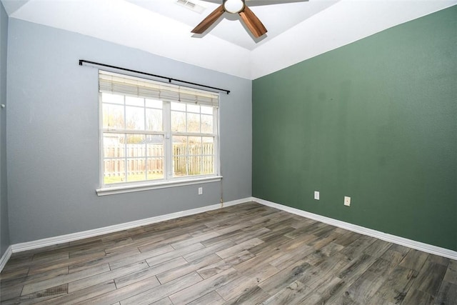 empty room with a ceiling fan, visible vents, baseboards, and wood finished floors