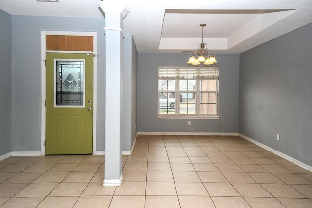 entryway featuring light tile patterned flooring, a tray ceiling, baseboards, and an inviting chandelier