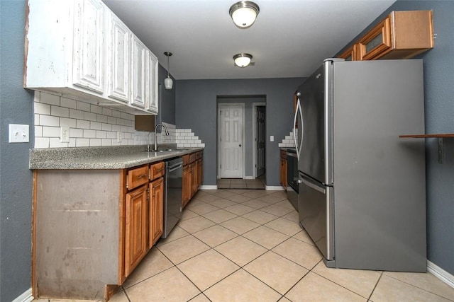 kitchen featuring decorative backsplash, a sink, dishwashing machine, light tile patterned floors, and freestanding refrigerator
