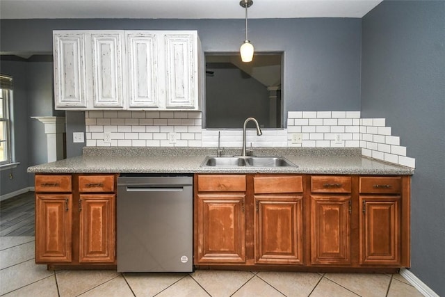 kitchen featuring a sink, tasteful backsplash, decorative light fixtures, and stainless steel dishwasher