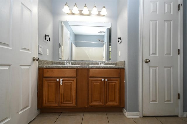 bathroom with tile patterned floors, a shower, double vanity, and a sink