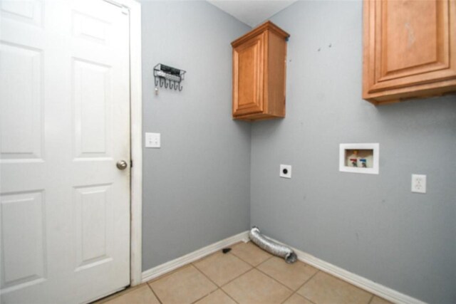 laundry area with washer hookup, hookup for an electric dryer, light tile patterned floors, baseboards, and cabinet space