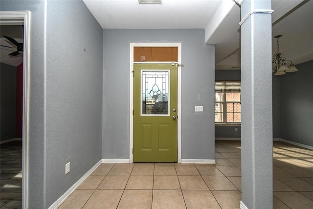 entryway featuring baseboards, visible vents, decorative columns, and light tile patterned floors