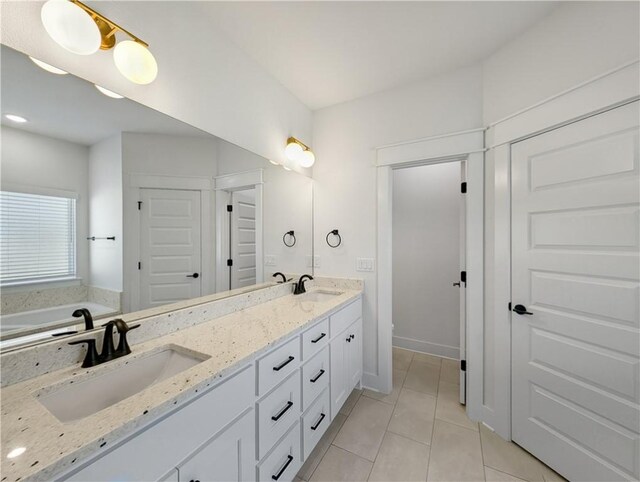 bathroom featuring tile patterned flooring, vanity, and a bathing tub