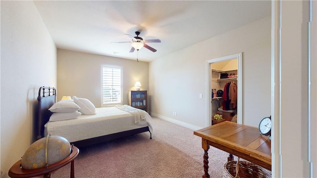 bedroom featuring a spacious closet, ceiling fan, and carpet