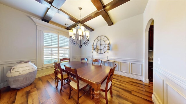 dining room with hardwood / wood-style flooring, coffered ceiling, a chandelier, and beam ceiling