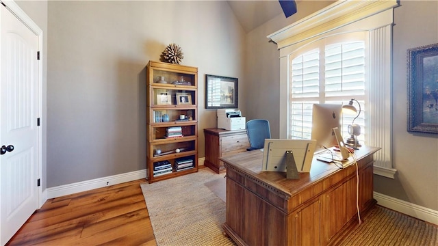 office space with vaulted ceiling and light wood-type flooring