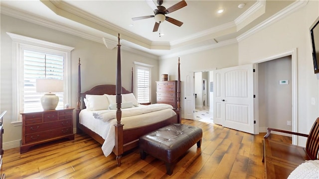 bedroom featuring hardwood / wood-style floors, ornamental molding, and a raised ceiling