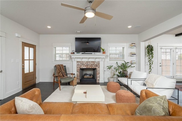 living room with ceiling fan, wood-type flooring, and a fireplace