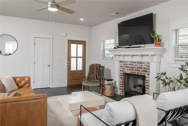 living room with ceiling fan, dark hardwood / wood-style floors, and a fireplace