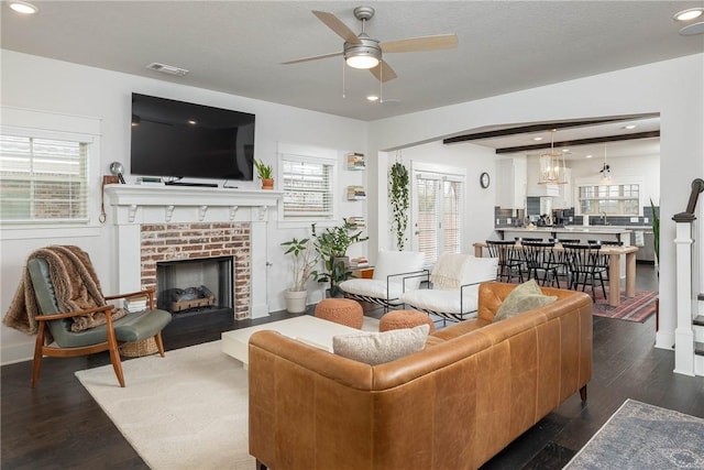 living room with dark hardwood / wood-style flooring, sink, a fireplace, and ceiling fan