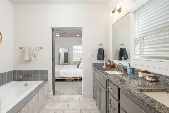 bathroom featuring vanity, a relaxing tiled tub, tile patterned floors, and ceiling fan