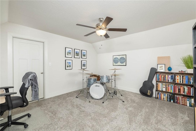 carpeted home office featuring vaulted ceiling, ceiling fan, and a textured ceiling