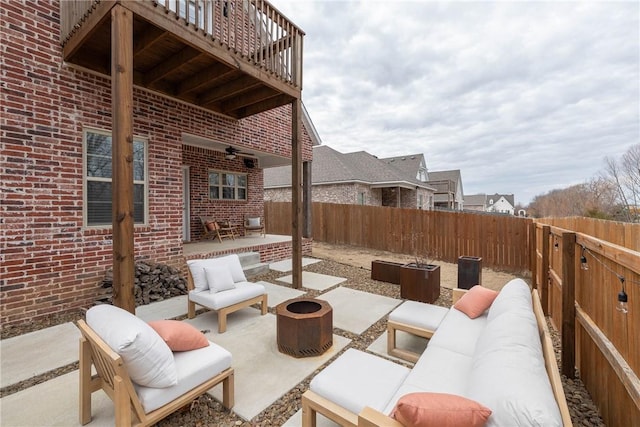 view of patio / terrace with ceiling fan and an outdoor living space with a fire pit