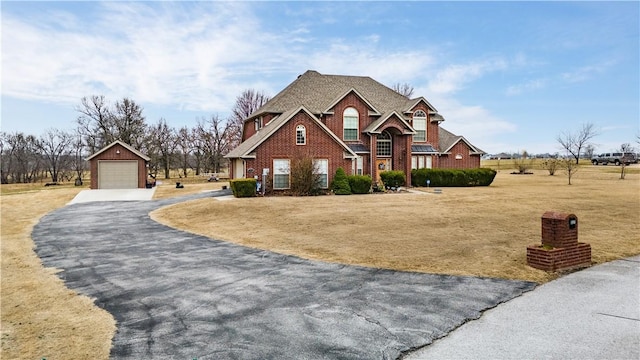 view of front of house with a garage, an outdoor structure, and a front yard