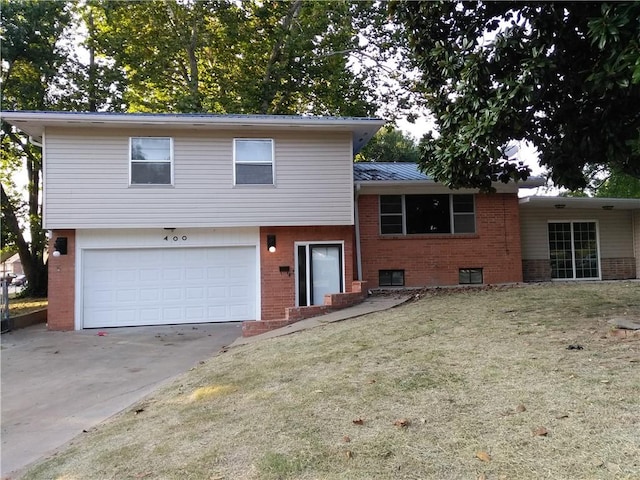 tri-level home featuring a garage and a front yard