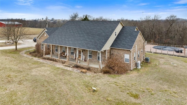 exterior space featuring a patio, a covered pool, central AC, and a front lawn