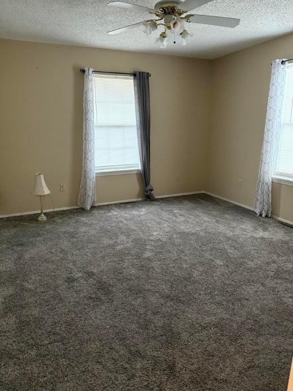 carpeted spare room with ceiling fan and a textured ceiling