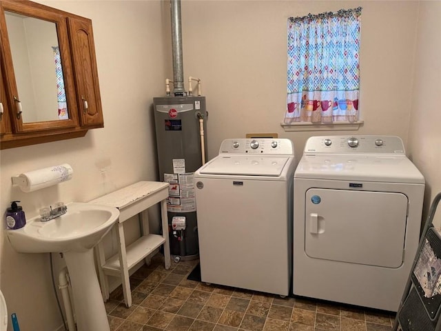 laundry room featuring cabinets, gas water heater, and separate washer and dryer