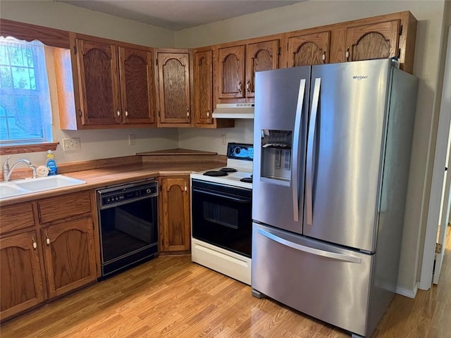 kitchen featuring sink, electric range oven, black dishwasher, stainless steel refrigerator with ice dispenser, and light hardwood / wood-style floors