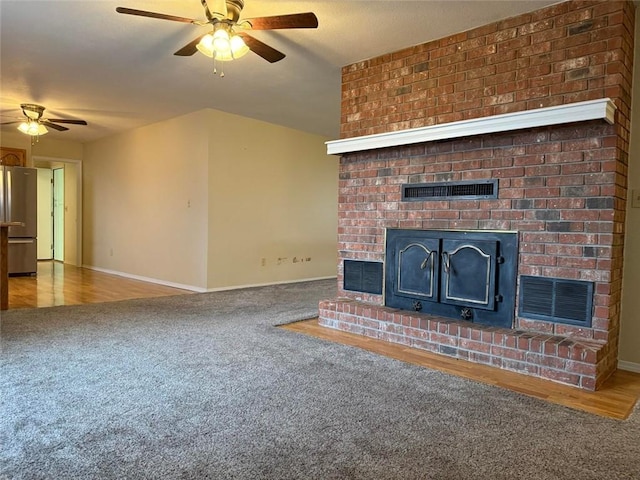 unfurnished living room featuring ceiling fan, carpet, and a fireplace