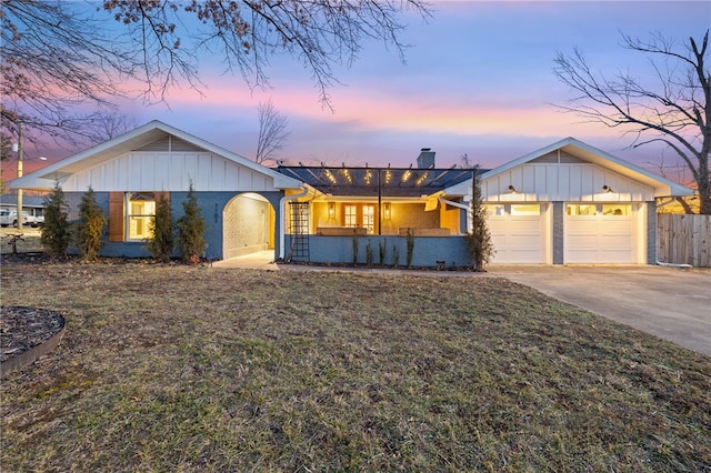 ranch-style house featuring a garage and a yard