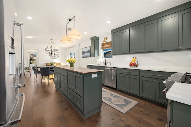 kitchen with stainless steel dishwasher, dark hardwood / wood-style floors, a center island, and hanging light fixtures