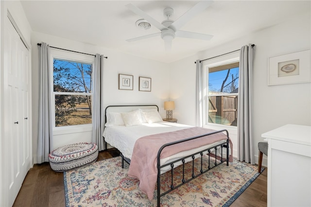 bedroom with dark wood-type flooring, ceiling fan, and a closet