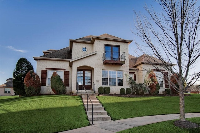 mediterranean / spanish house featuring a balcony and a front lawn