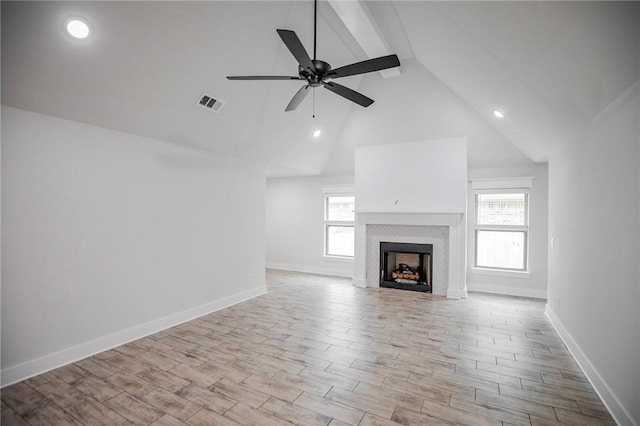 unfurnished living room with ceiling fan, high vaulted ceiling, and light wood-type flooring