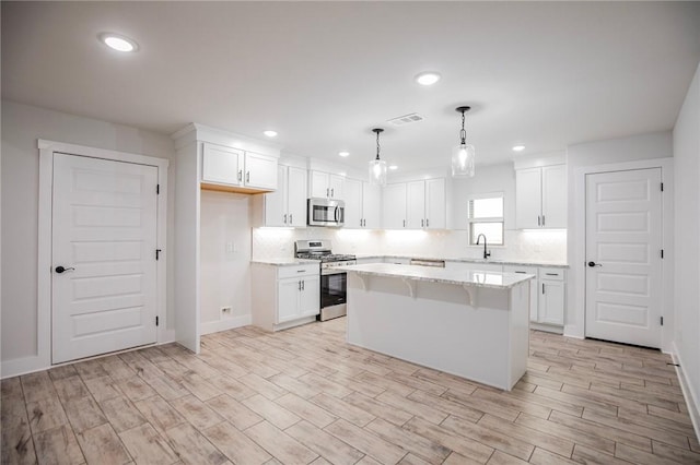 kitchen featuring white cabinetry, appliances with stainless steel finishes, and a kitchen island