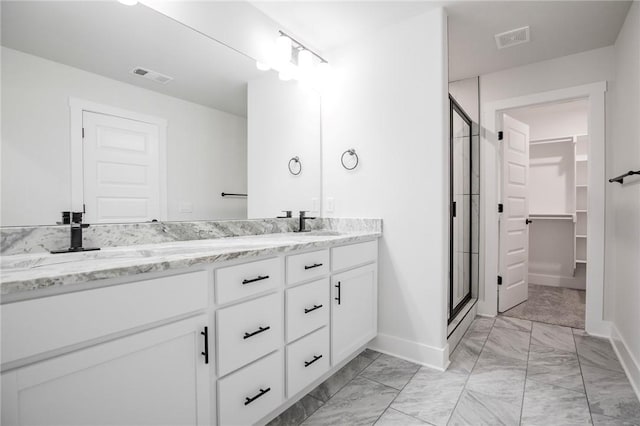 bathroom with a shower with door and vanity