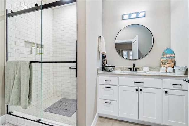 bathroom featuring a shower with door, vanity, and tile patterned floors