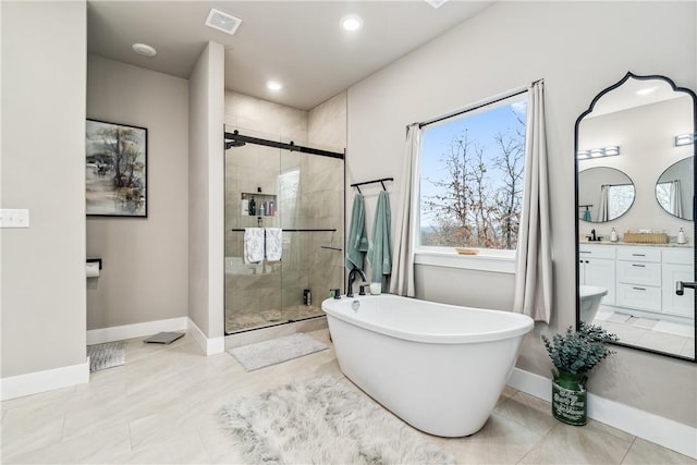 bathroom featuring tile patterned flooring, plus walk in shower, and vanity