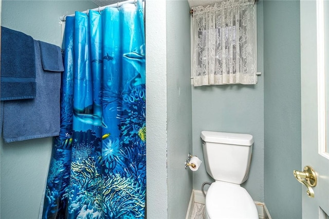 bathroom with a shower with curtain and toilet