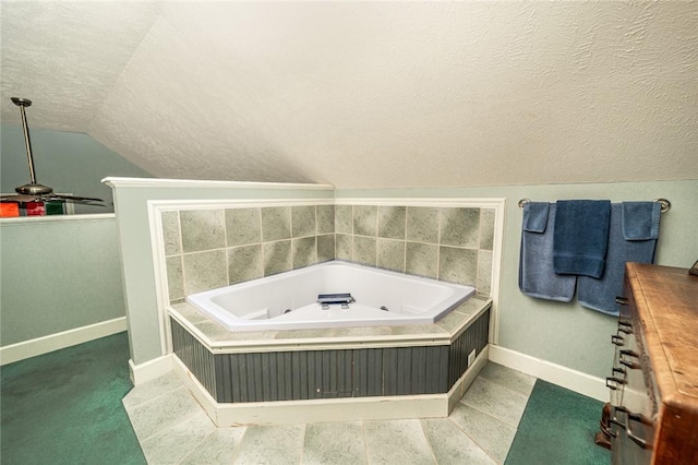 bathroom with a bathing tub, lofted ceiling, and a textured ceiling