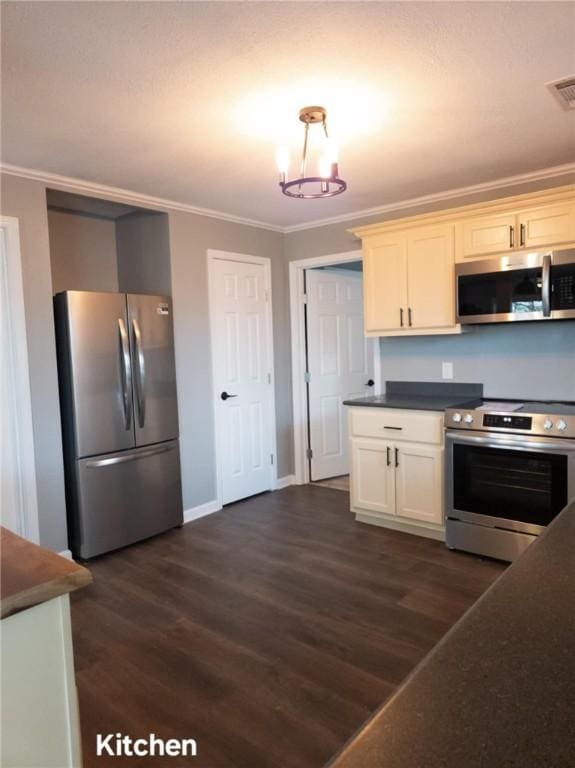 kitchen with stainless steel appliances, white cabinetry, dark wood-style floors, dark countertops, and crown molding