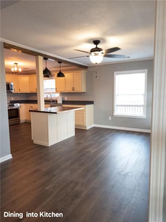 kitchen featuring dark countertops, dark wood-style floors, stainless steel appliances, and hanging light fixtures