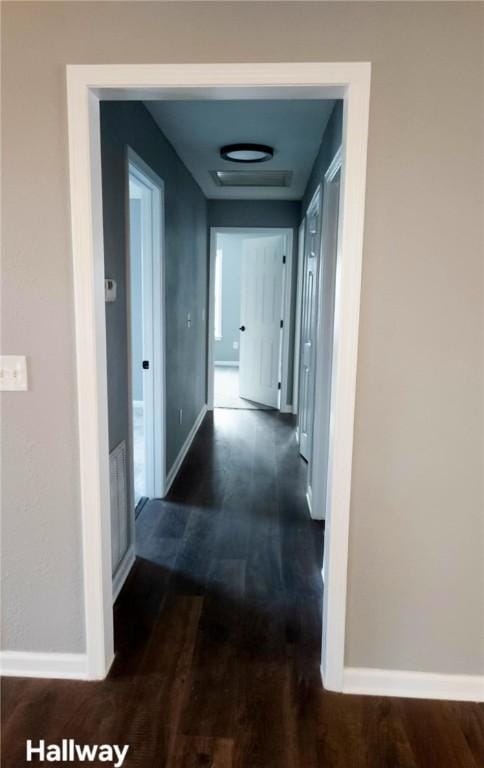 hallway with dark wood-style floors and baseboards