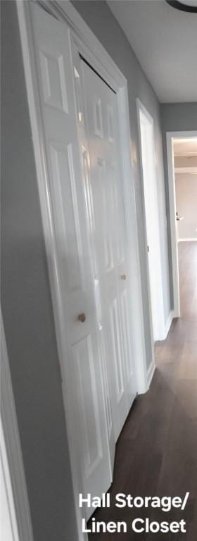 corridor with baseboards and dark wood-style flooring